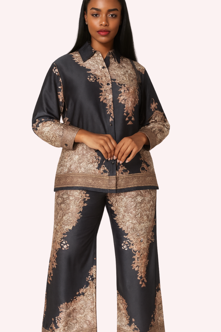 Model wearing navy baroque print satin pant set with button-down top and wide-leg pants by For Her NYC.