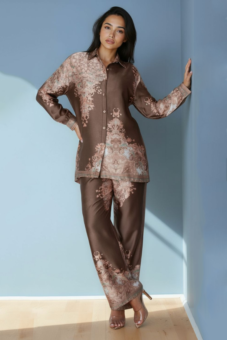 Model wearing olive baroque print satin pant set with long-sleeve top and wide-leg pants by For Her NYC.