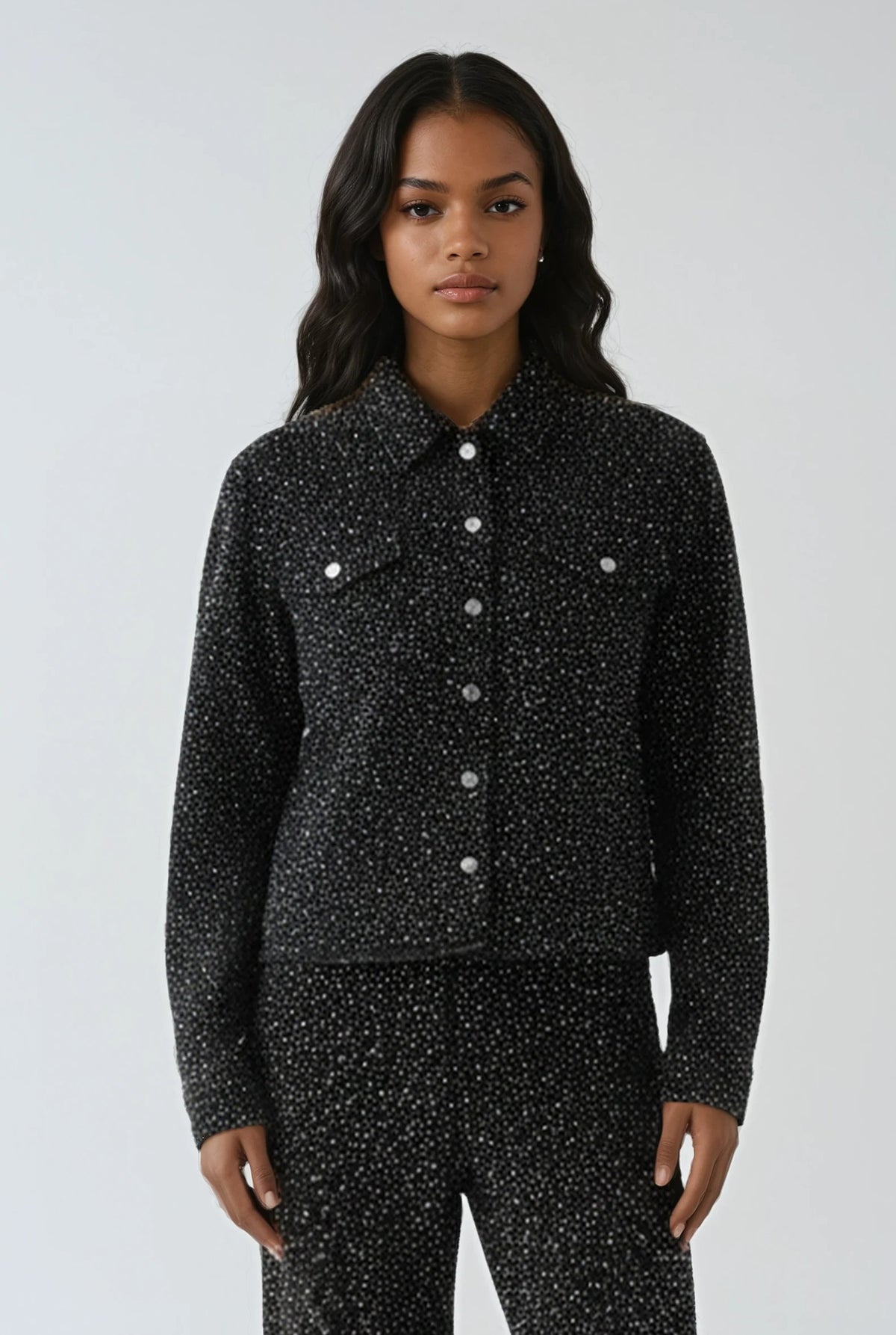 Model wearing black rhinestone denim jacket with light frayed edges by For Her NYC, styled for a casual chic look.