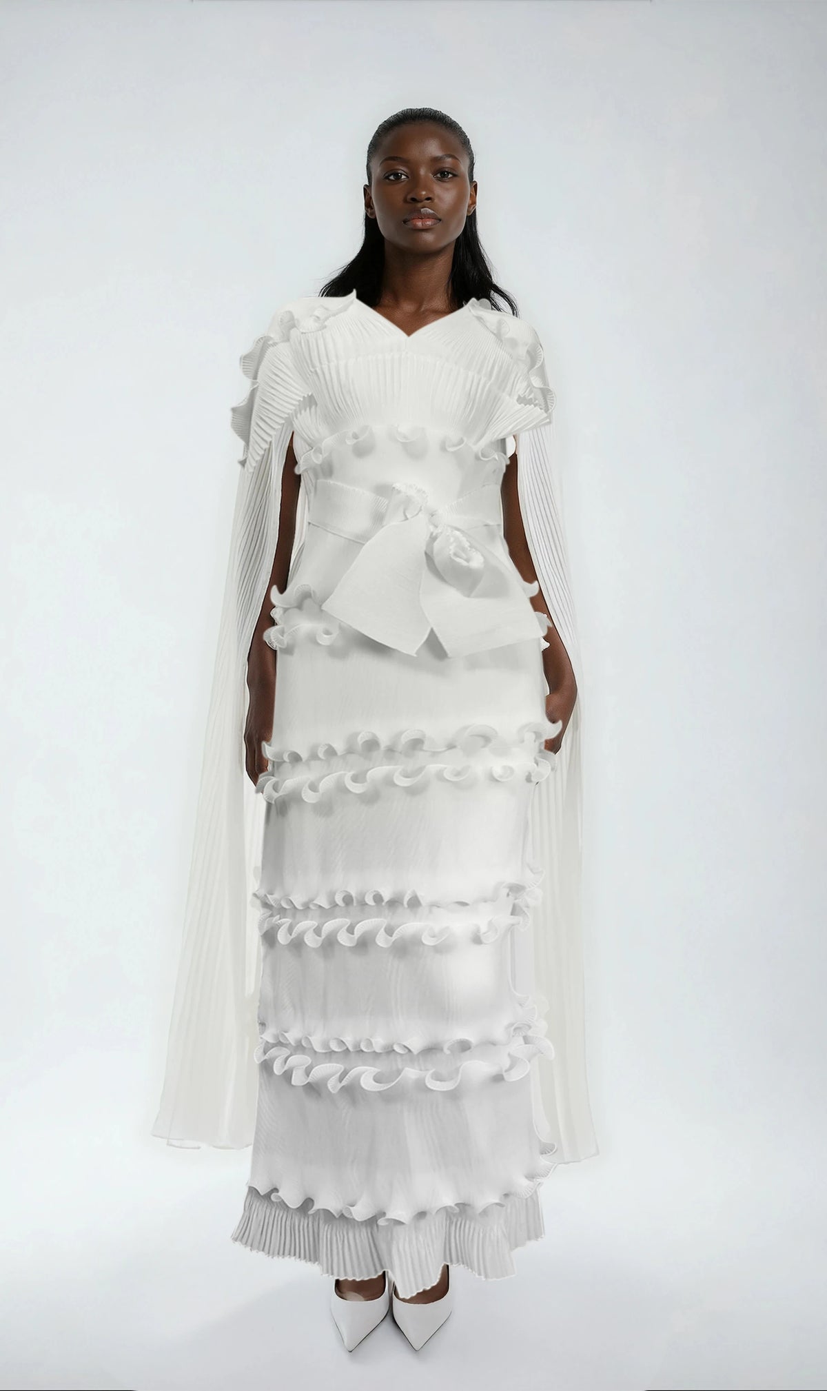 Model wearing white ruffled pleated maxi dress with matching scarf and waist tie by For Her NYC.