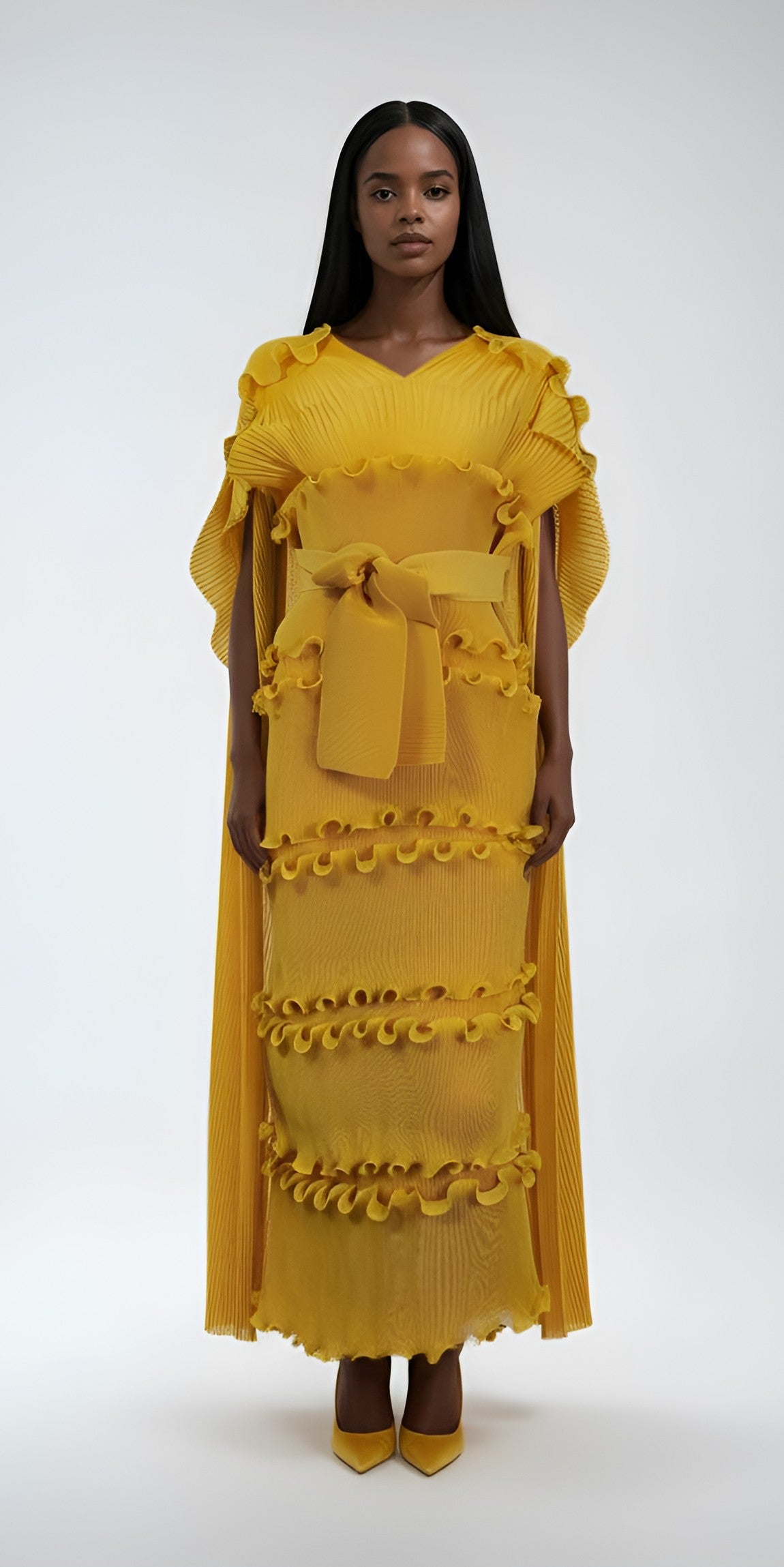 Model wearing yellow ruffled pleated maxi dress with cascading scarf and belted waist by For Her NYC.