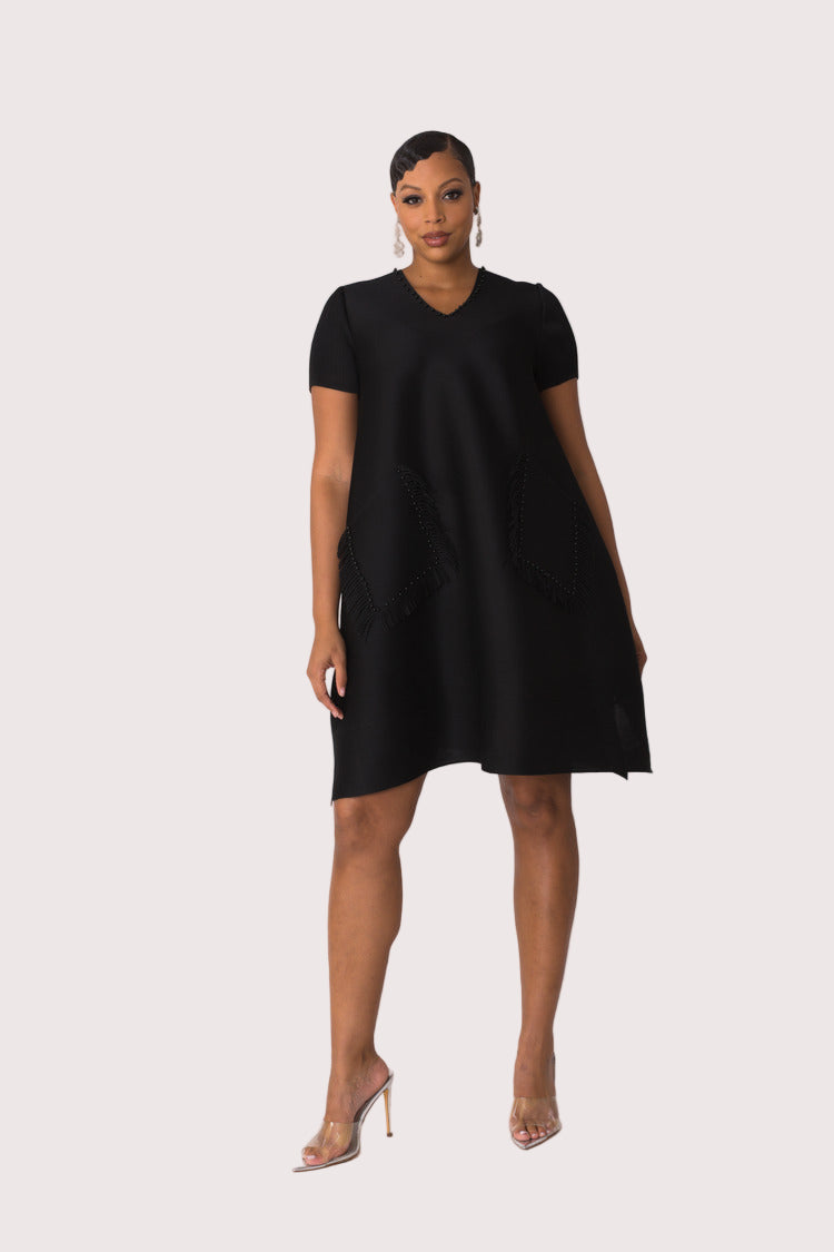 Front view of model wearing the black fringe pocket shift dress with short sleeves and V neckline, polished minimal look by For Her NYC