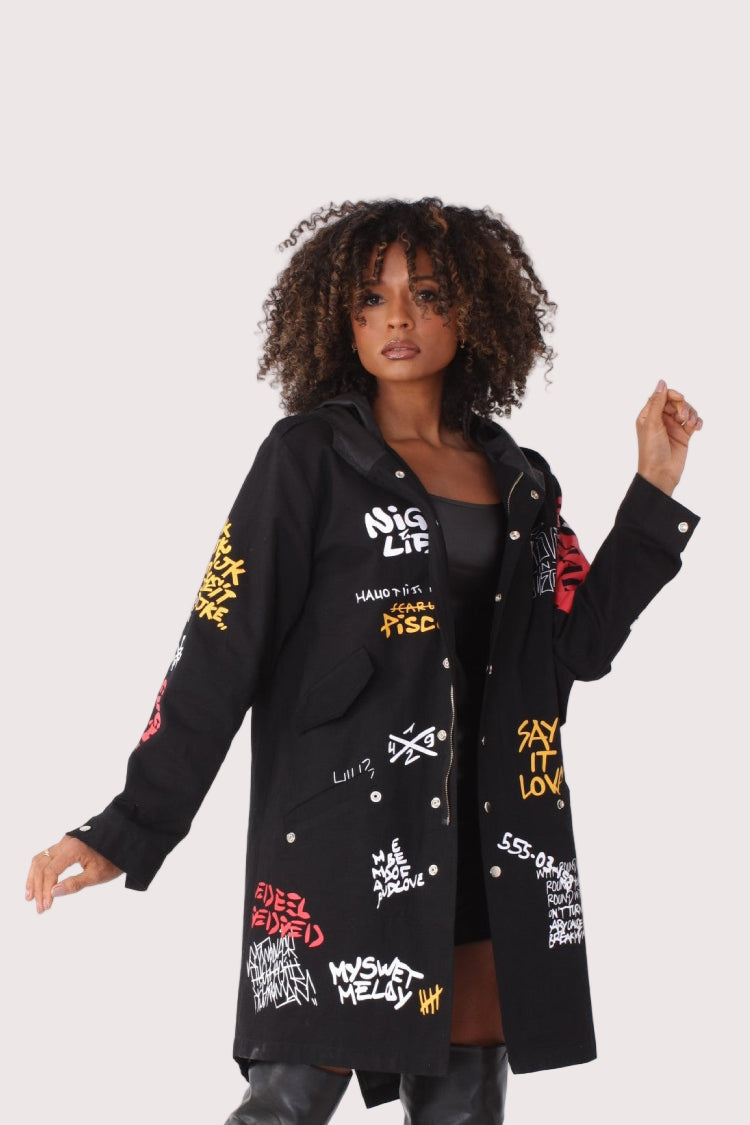 Black graffiti print oversized jacket front view with bold streetwear graphics and relaxed longline silhouette.