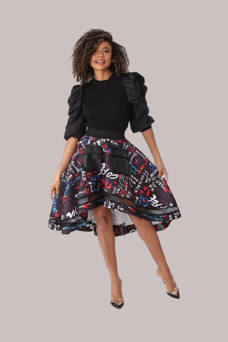 Front pose with skirt movement emphasizing the dramatic high-low hemline, bold graphic pattern, and netting overlay by For Her NYC
