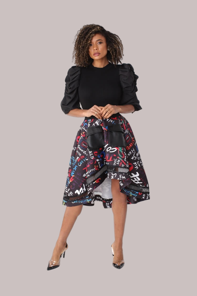 Front walking pose showcasing graphic scuba skirt with flowing movement, high-low hem, and modern netting detail by For Her NYC