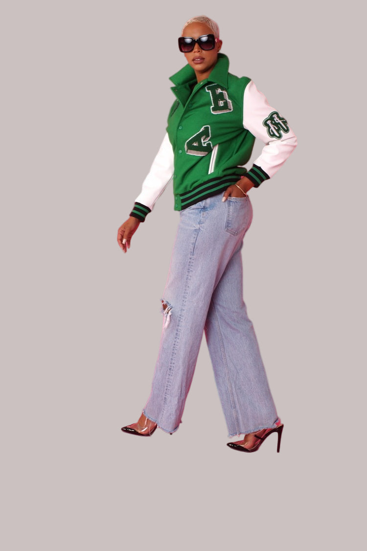 Angled front pose wearing green varsity jacket with white sleeves – For Her NYC