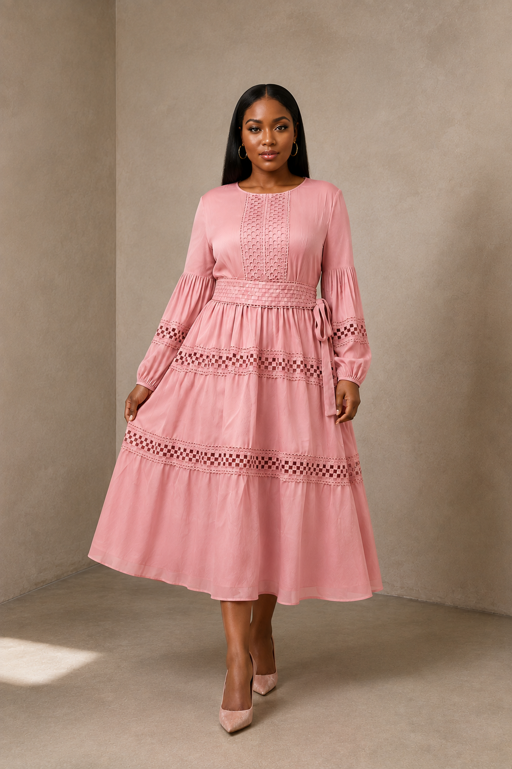 Front view of model wearing a pink long sleeve tiered midi dress with soft pleating and lace detailing, For Her NYC