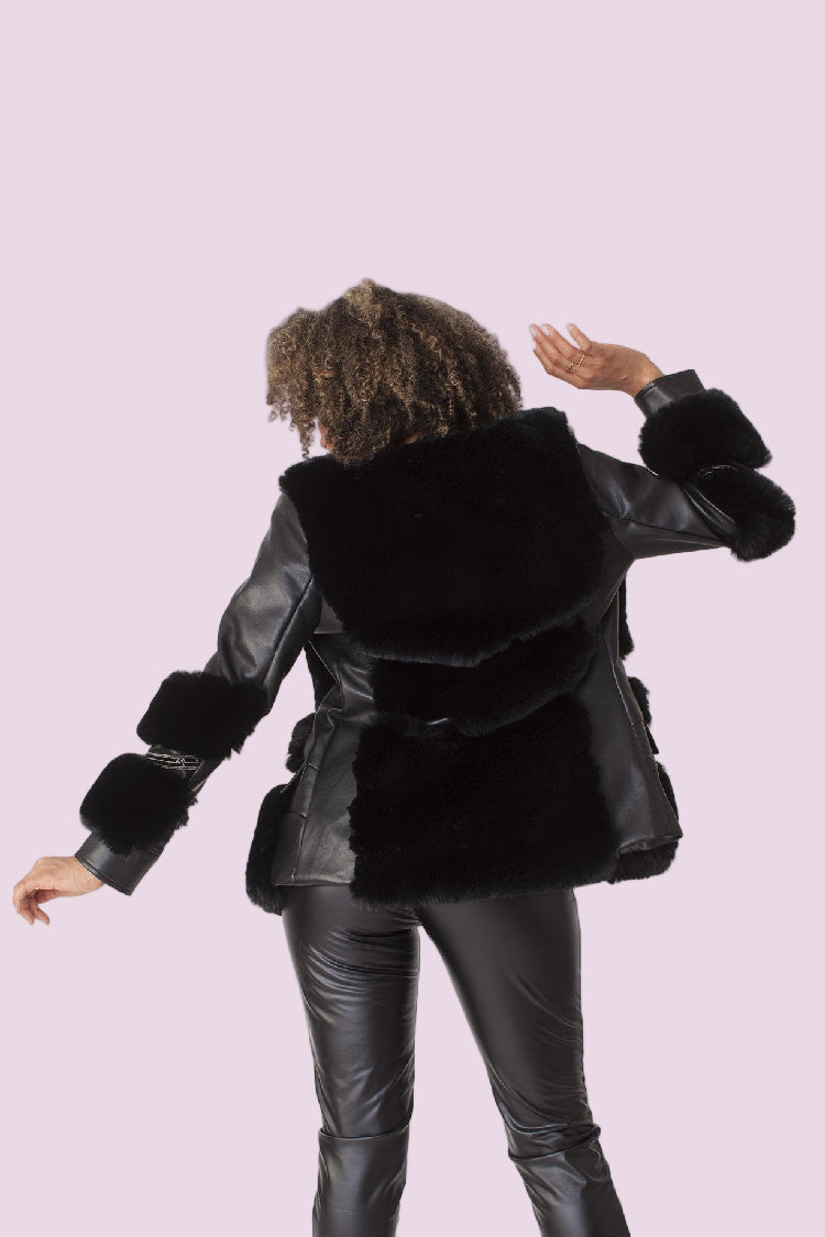 Back view of model wearing a black faux leather jacket with fur trim, showcasing the structured fit and plush fur detailing, For Her NYC