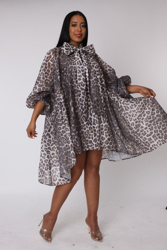 Sheer leopard print organza bow dress with voluminous sleeves and oversized bow shown front view.
