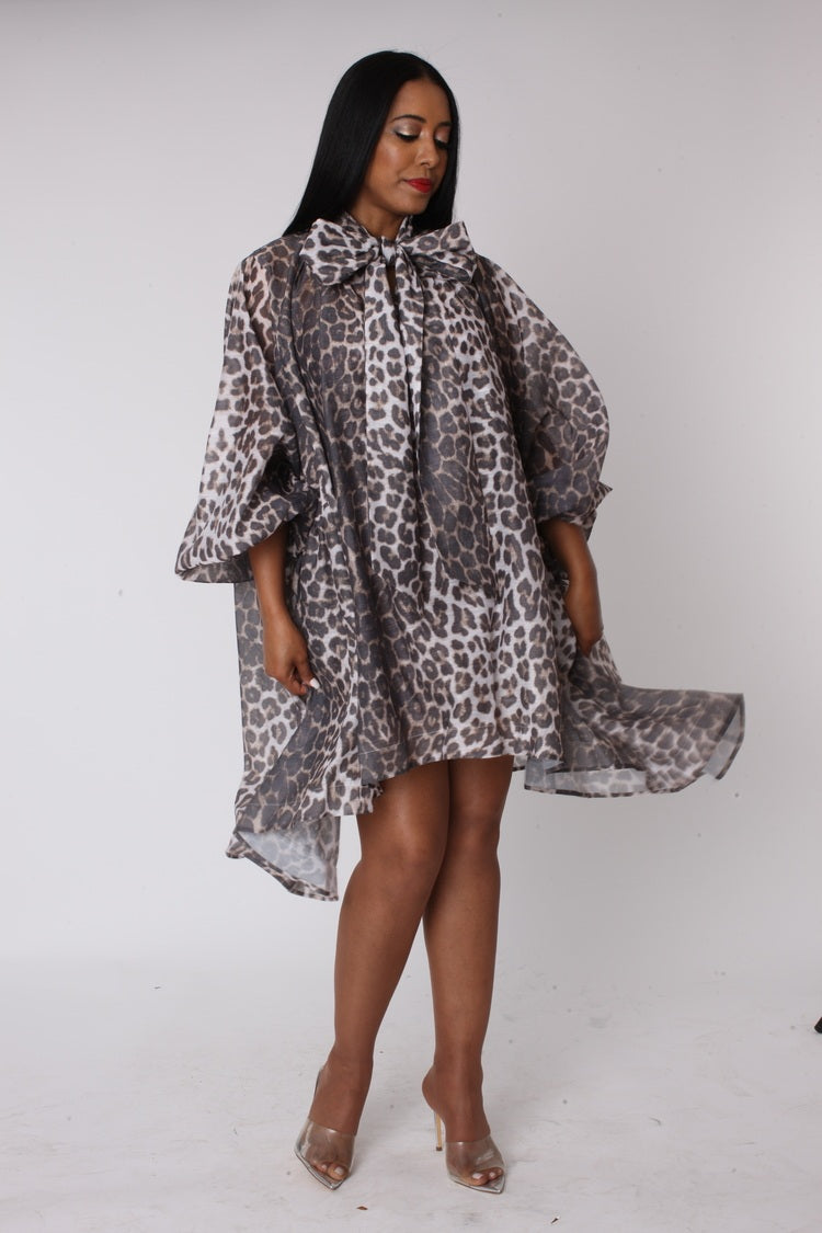 Side angled view of sheer leopard organza bow dress highlighting volume and oversized bow design.