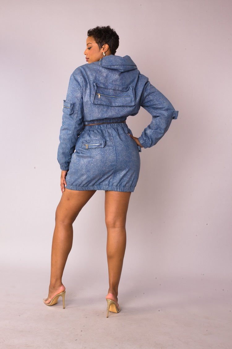 Three quarter angled view of model wearing the denim silver metallic shimmer mini skirt highlighting structured fit and subtle shine by For Her NYC