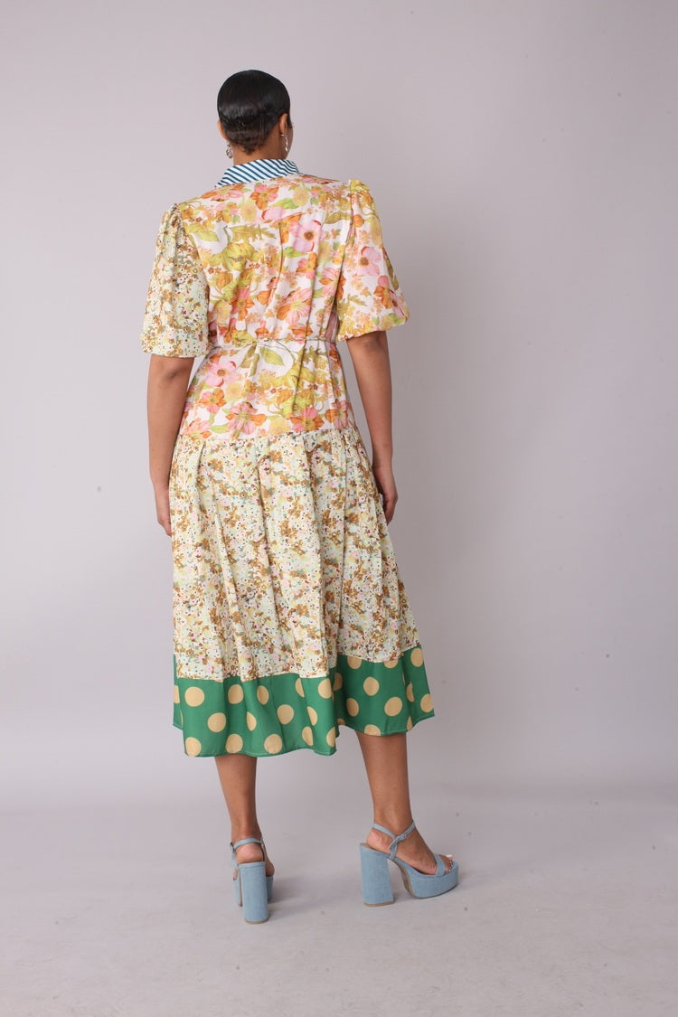 Back view of model wearing the multi print mixed print midi dress showing full skirt volume and contrasting pattern details by For Her NYC