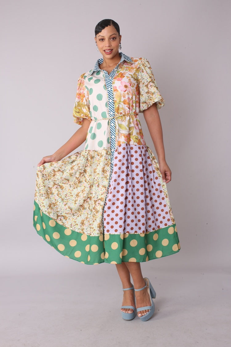 Model wearing the multi print mixed print midi dress standing front facing, showcasing playful mix of florals, polka dots, and stripes with puff sleeves by For Her NYC