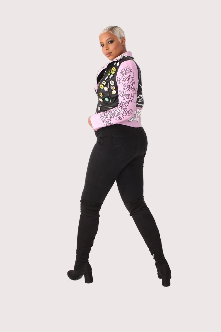 Model wearing multicolor faux leather jacket with pins and studs, side angle pose highlighting moto zipper, studded details, and tailored fit by For Her NYC