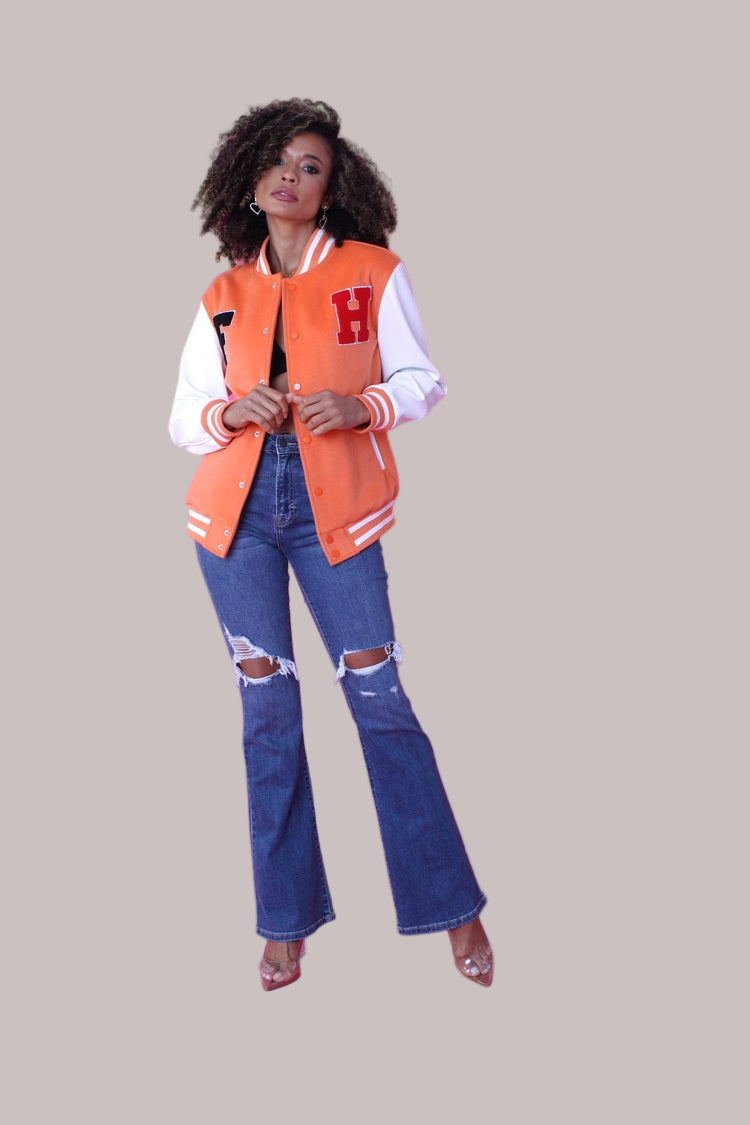 Slight angled open stance of orange varsity jacket showing front detail – For Her NYC