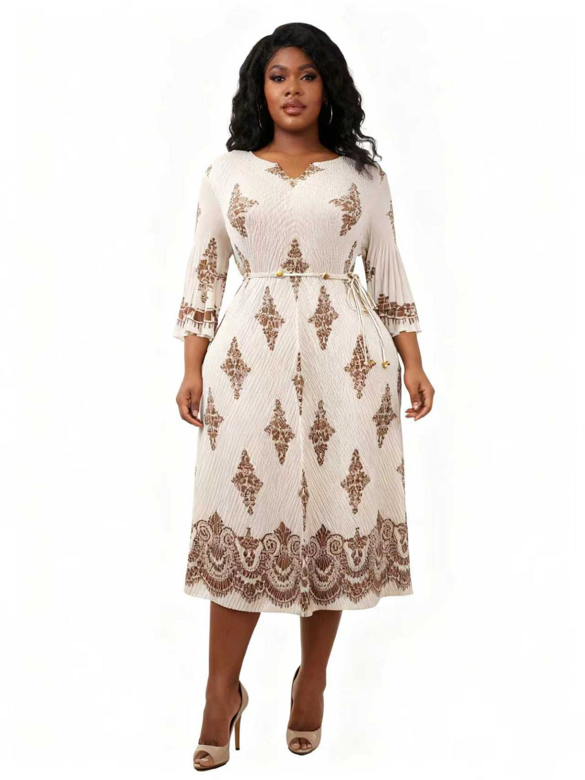 Model wearing an ornate printed midi dress with border hem detail and waist tie, front view – For Her NYC