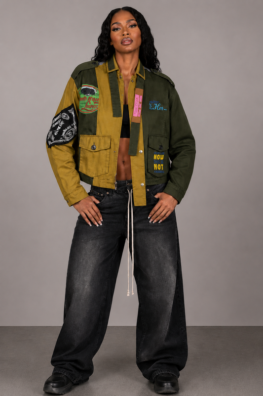 Army green patchwork utility woven jacket with mixed patch detailing and soft woven fabric, seated lifestyle view by For Her NYC