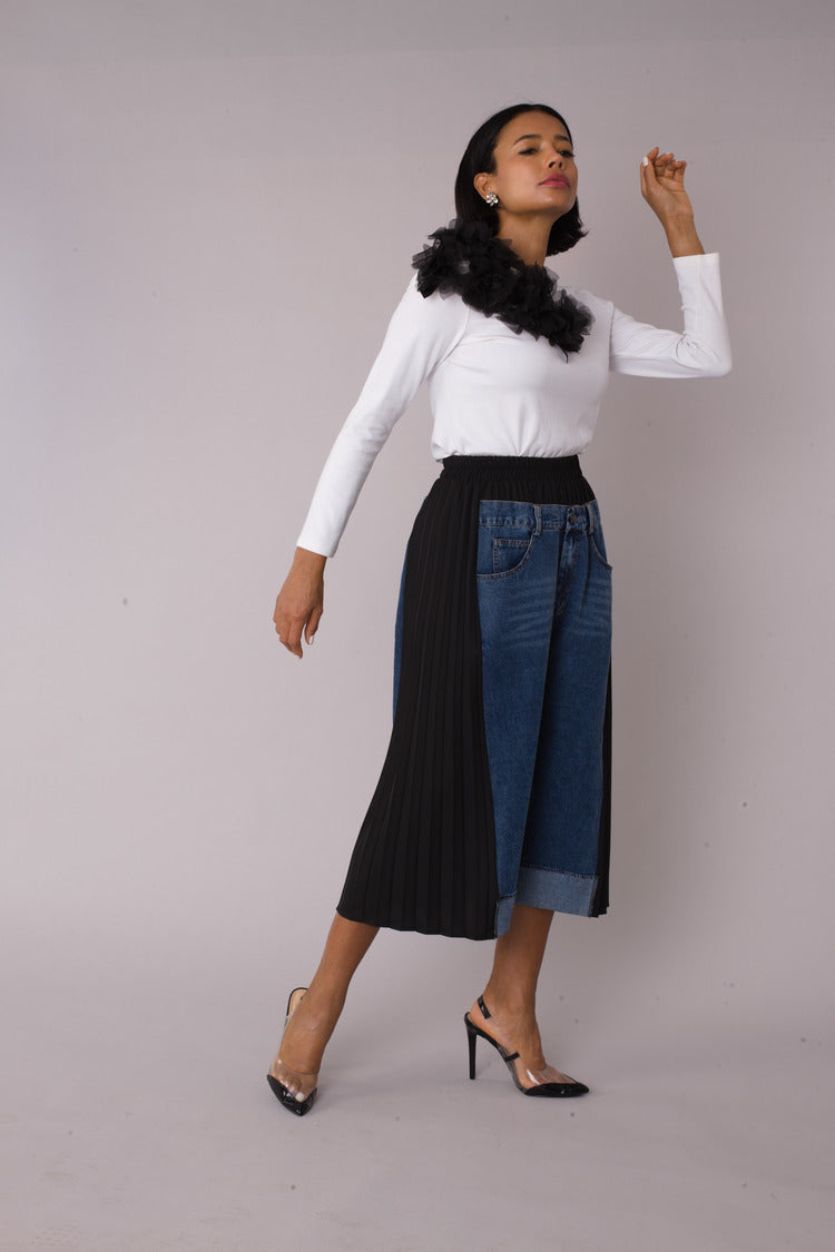 Model wearing Pleated Panel Denim Culottes with arm raised pose emphasizing high-waist fit and pleated panel detail, For Her NYC