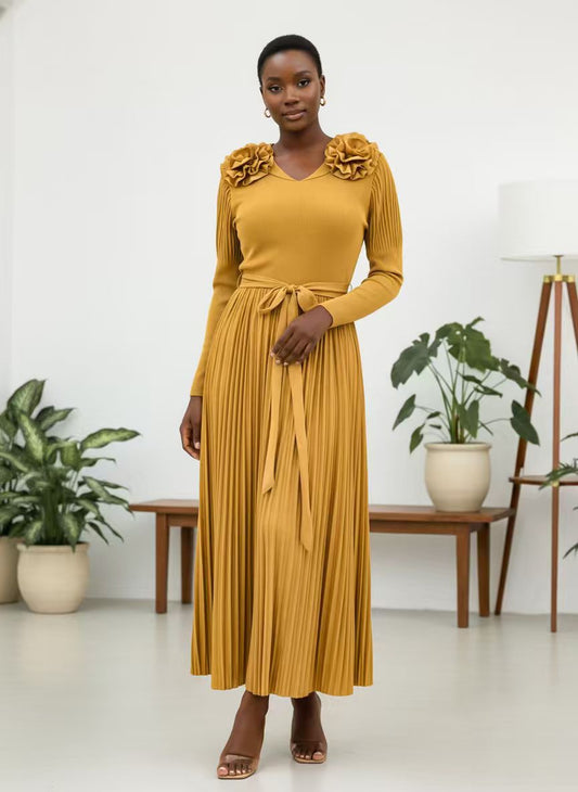 Mustard pleated midi dress with rosette shoulders and tie waist, model standing front with hands clasped, For Her NYC