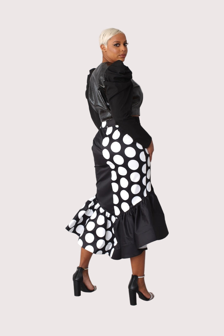 Black and white dotted high low skirt turning pose showing asymmetrical shape.