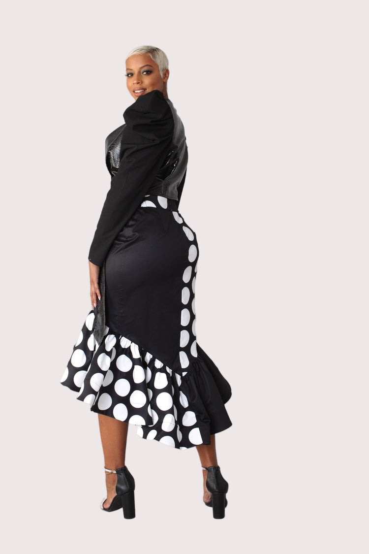 Black and white dotted high low skirt turning pose showing asymmetrical shape.