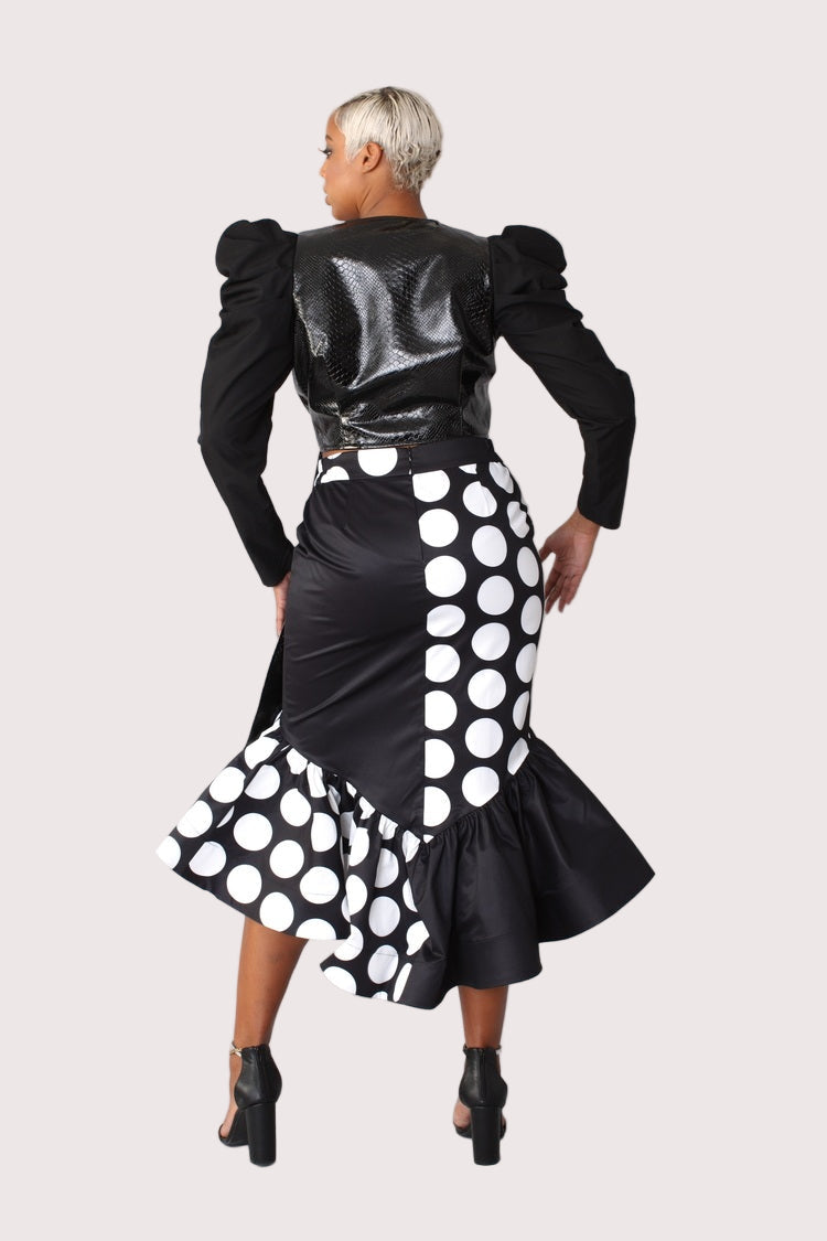 Black and white polka dot printed high low skirt back view showing asymmetrical hem and statement dot pattern.