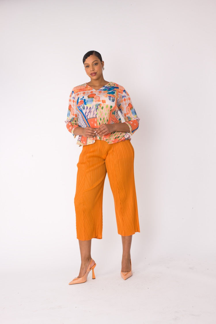 Alternate front standing view of a printed top and palazzo pants set in orange multi with a lightweight flowy silhouette by For Her NYC
