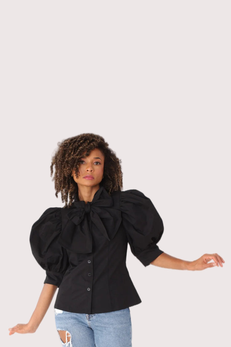 Front view of black puff sleeve tie neck blouse with voluminous sleeves and feminine bow neckline, modern polished look, For Her NYC