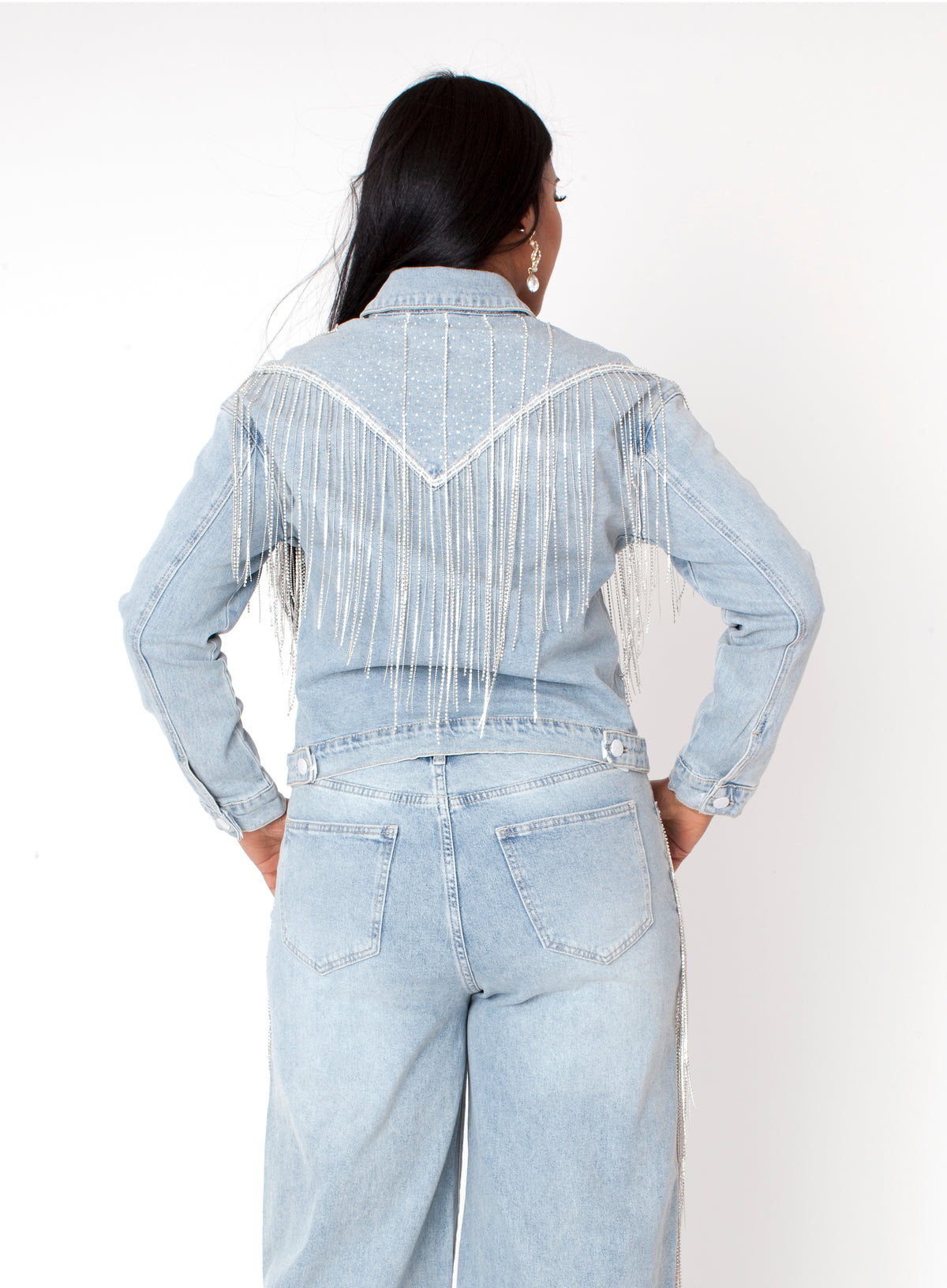 Wash blue denim rhinestone fringe jacket featuring dramatic fringe detailing across the back, back view highlighting movement and design by For Her NYC