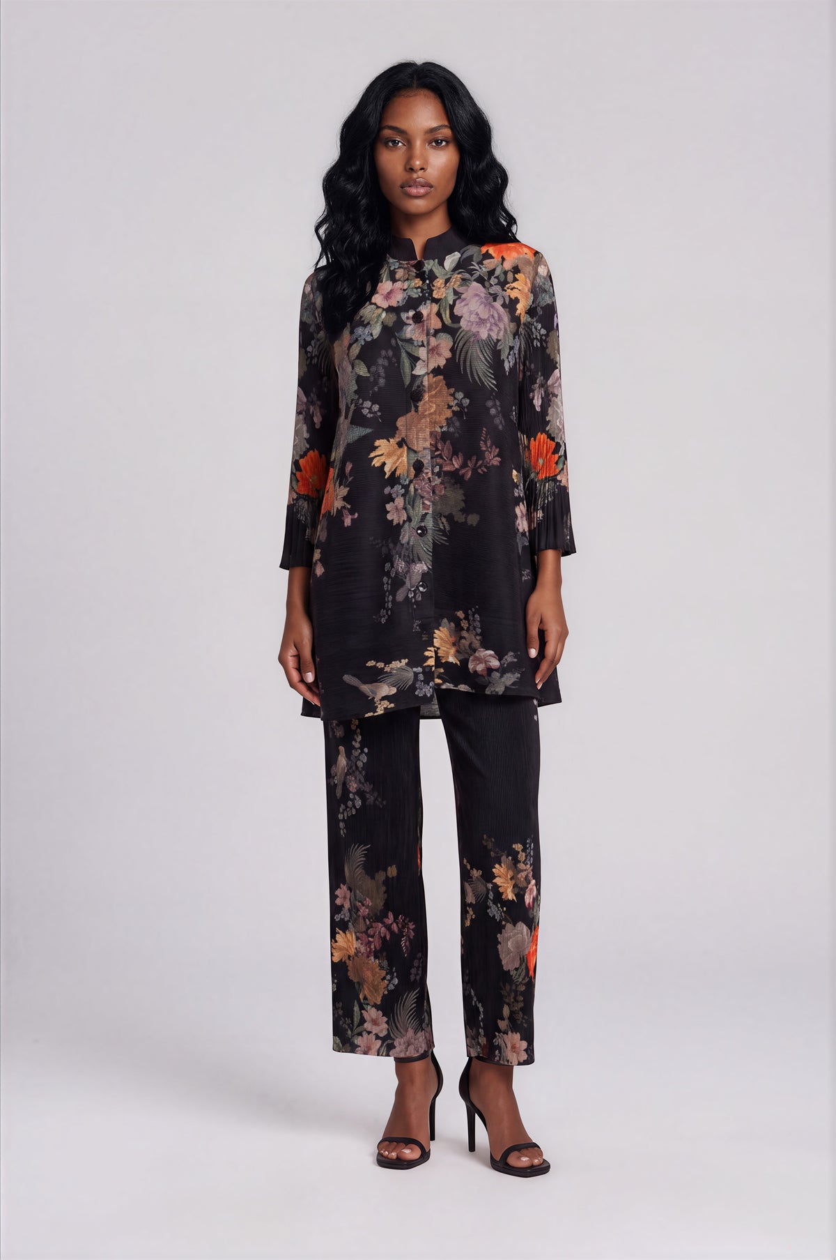 For Her NYC Plus Size Spring Garden Print Tunic Pant Set in Black Multi featuring a vibrant floral print, button-front long tunic with a graceful high-low hem, coordinating straight-leg pants, and a flattering two-piece silhouette.