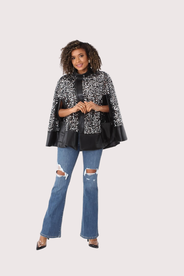 Left angled view of black sequin cape with faux leather trim — For Her NYC.