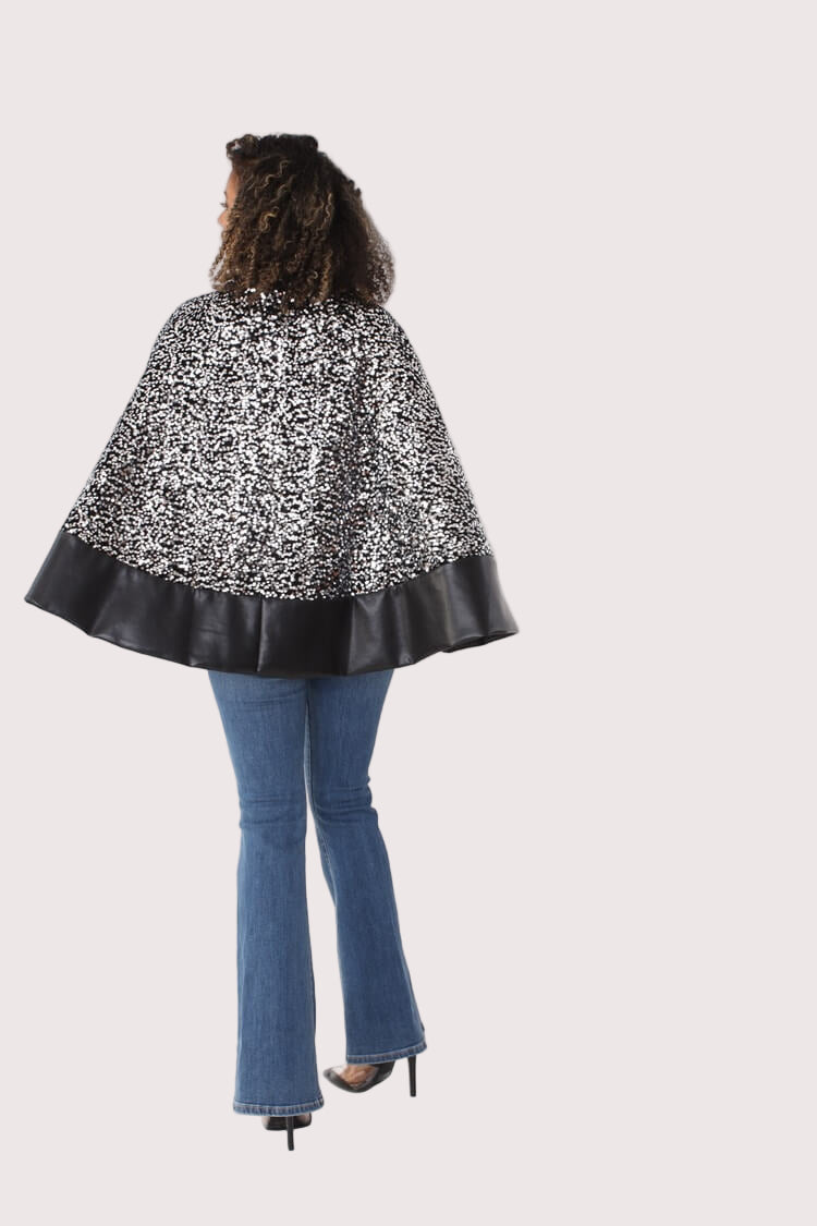 Back view of black sequin cape with faux leather trim — For Her NYC.