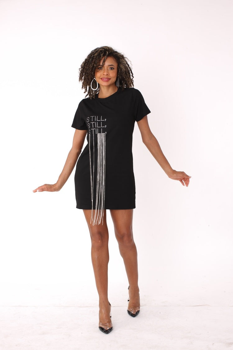 Front walking view of black and white “Still” graphic t-shirt dress with bold vertical typography and easy casual fit by For Her NYC