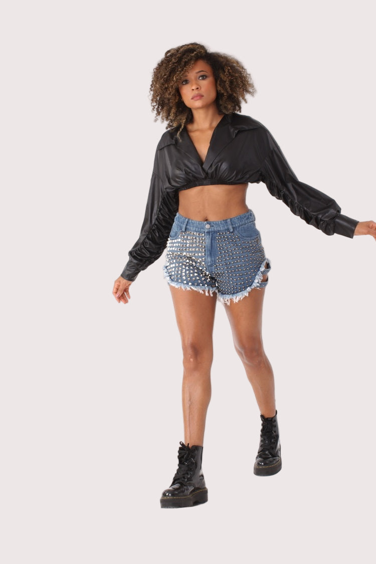 Model in motion wearing studded denim shorts with pearl accents, edgy casual look with combat boots and cropped top, For Her NYC