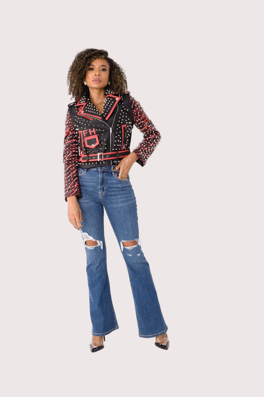 Model wearing a black and red studded leather jacket with detachable sleeves in a front standing pose, showcasing silver stud detailing and fitted silhouette, For Her NYC