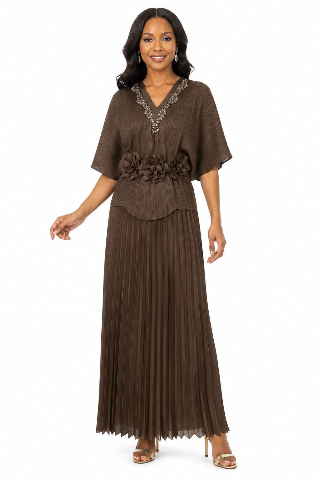 Model wearing the Tally Taylor Embellished Pleated Midi Dress in brown, featuring a jeweled V-neckline, floral waist embellishments, and pleated skirt, style S0269.