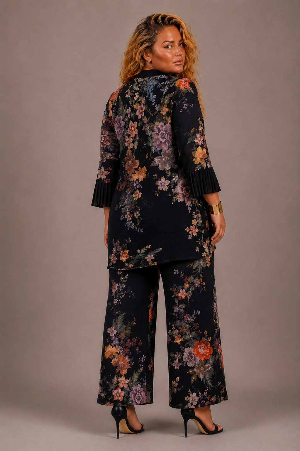 Plus size model showing the back of the Tally Taylor Spring Garden Print Tunic Pant Set in black with multicolor floral print and matching pants, style S0105W.