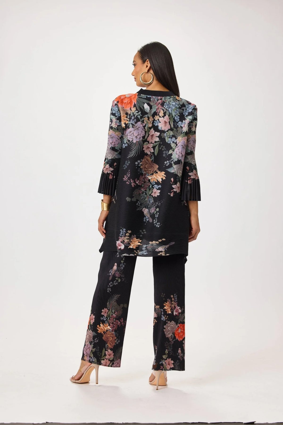 Model wearing the Tally Taylor Spring Garden Print Tunic Pant Set in black with multicolor floral print, button-front tunic and matching pants, style S0105.