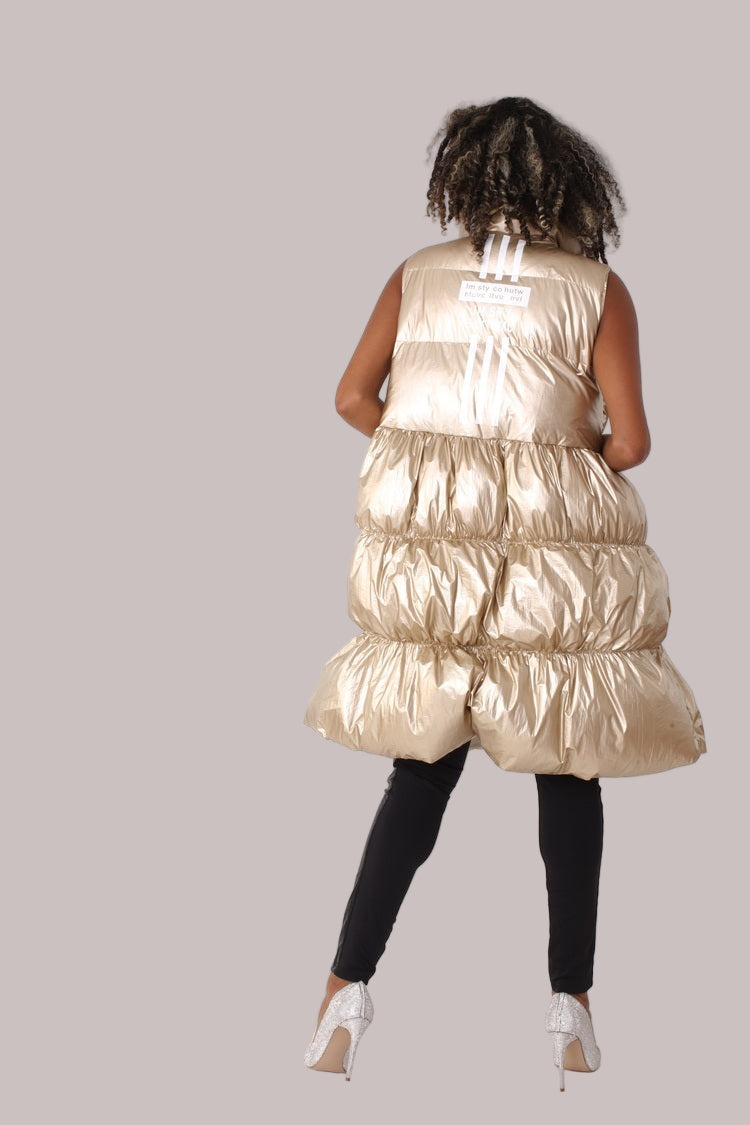 Rear angled view of nude tiered puffer vest showing length and volume — For Her NYC.