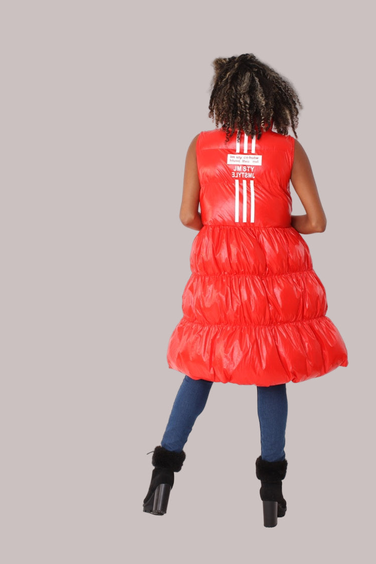 Back view of red tiered puffer vest showing WORLD-1987 logo and vertical stripe detail — For Her NYC.