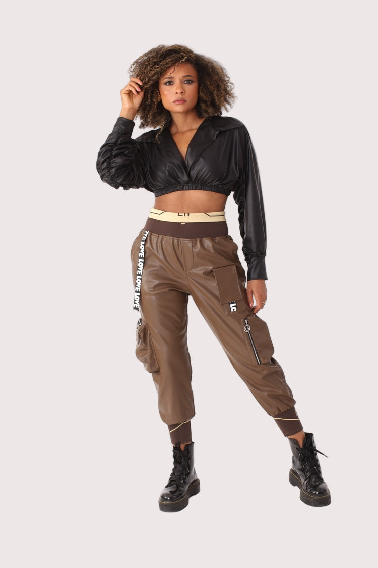 Model wearing brown vegan leather cargo joggers with elastic ankle cuffs and zippered pockets, styled with cropped top and combat boots, For Her NYC