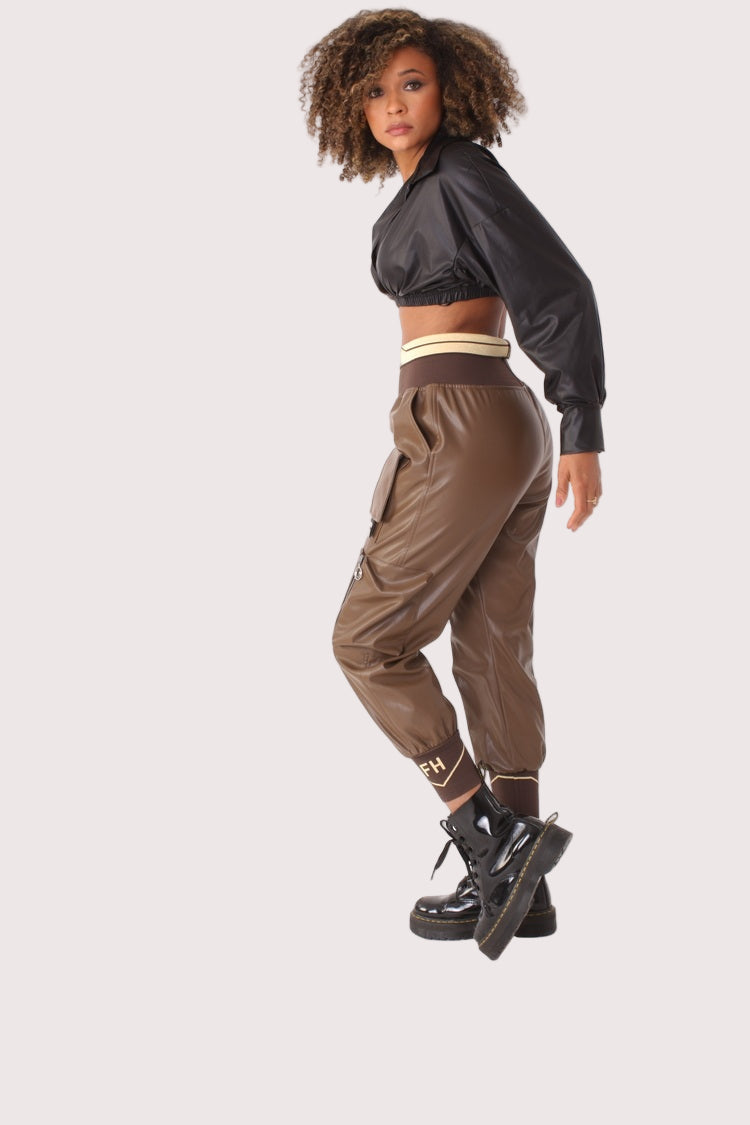 Side view of brown vegan leather cargo joggers highlighting utility pocket details and tapered jogger fit, edgy athleisure style, For Her NYC