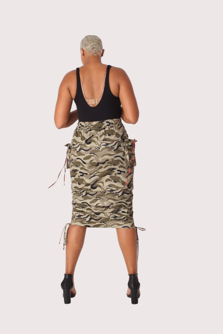 Back view of model wearing a camouflage woven midi skirt, displaying the fitted back and ruched waistband detail, For Her NYC