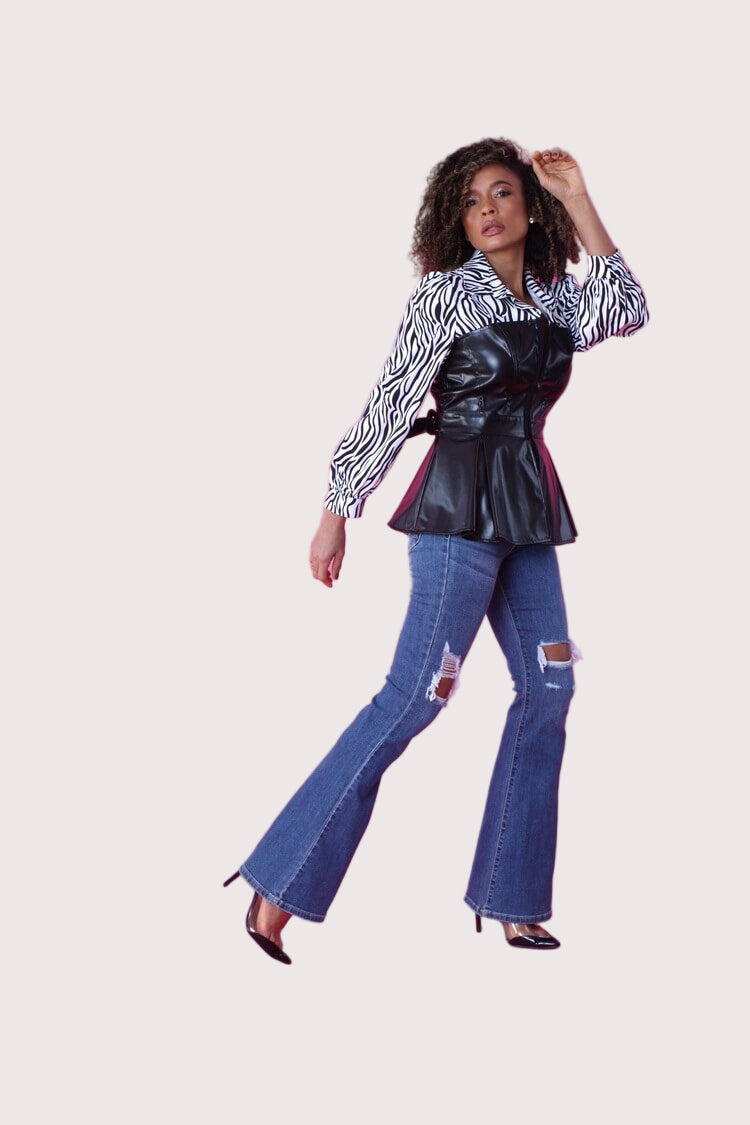 Side walking view of black and white zebra print peplum top with faux leather bodice – For Her NYC
